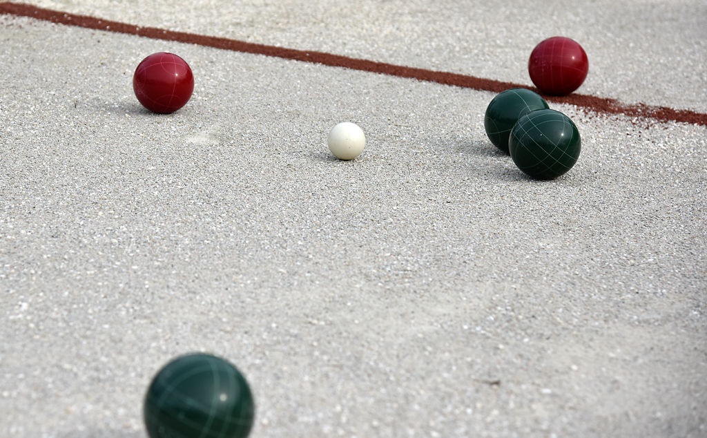 Bocce balls from the first game of bocce lay on the court